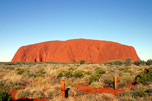 Der Ayers Rock/ Uluru ragt in Unweiten von Flachland auf